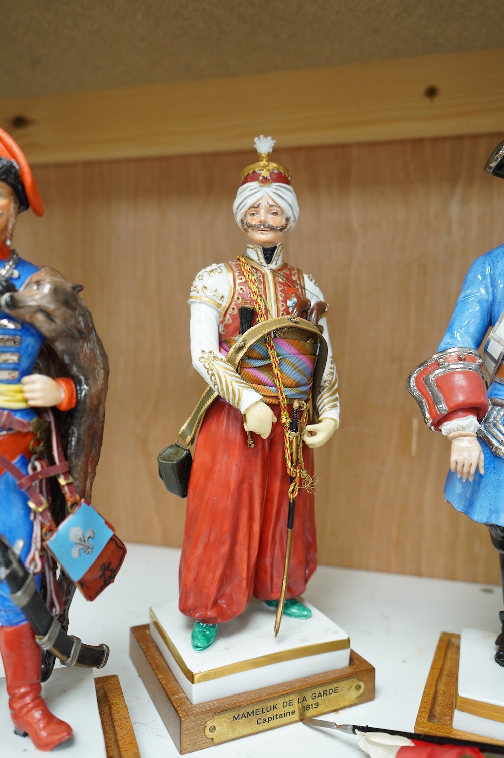 A set of four French porcelain military figures on stands to include ‘Hussards De Bercheny Officer’ and ‘Garde Du Corps’, largest 26cm high. Condition - mostly good condition with some minor losses